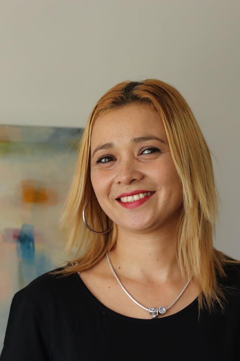 Home Portrait of a smiling blonde woman in Madrid against an abstract background.